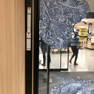 a woman walking through a store window