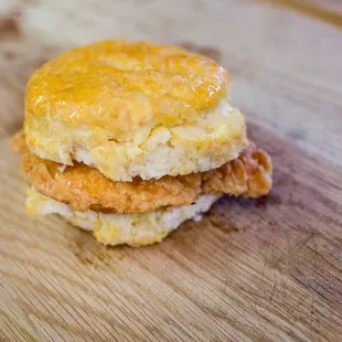 a biscuit sandwich on a wooden cutting board