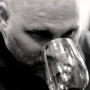 a man drinking a glass of wine