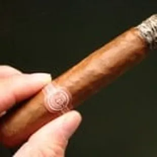 a hand holding a cigar