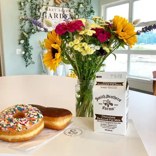 a vase of flowers and a box of doughnuts