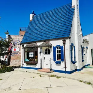 a small white house with blue shutters