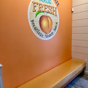 a bench in front of a peach sign