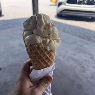 Peach ice cream on a waffle cone