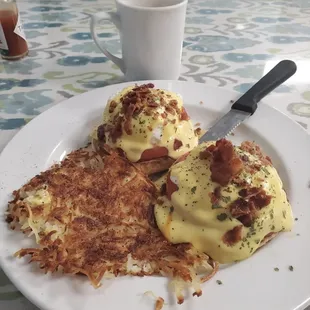 Eggs Benedict with tomato and crumbled bacon crispy hashbrown