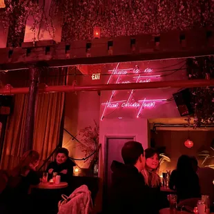 people sitting at tables in a dimly lit restaurant