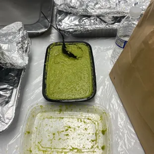 a tray of guacamole and a container of guacamole