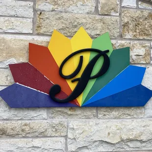a colorful sign on a brick wall