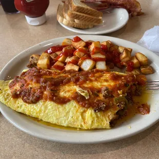 3 egg omelette with taco meat, jalapeño, onions, tomatoes, melted cheese topped with salsa. Home fries was perfect. Highly Recommended