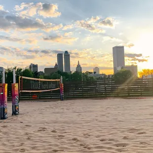a volleyball court with a city skyline in the background