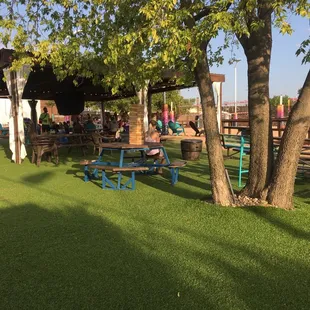 people sitting at tables under a tree