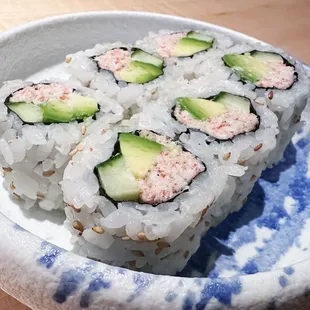 a plate of sushi with cucumbers on it