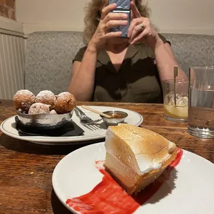 a woman taking a picture of a dessert