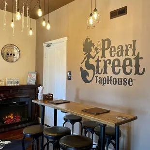 a bar with stools and a fire place