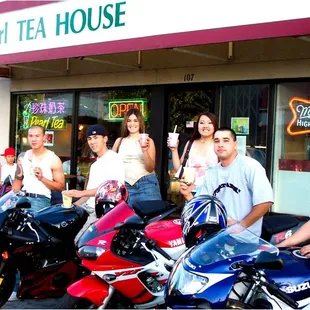 a group of people standing in front of motorcycles
