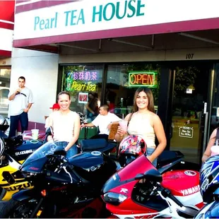 a group of women standing in front of their motorcycles