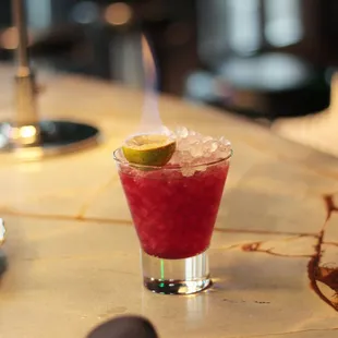 a cocktail with a lime on the rim