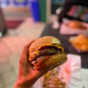 a hand holding a hamburger
