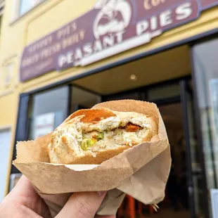 a hand holding a sandwich