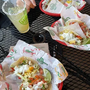 three tacos and a drink on a table