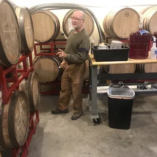 a man standing in front of barrels
