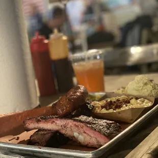 Three meat combo (rib, brisket, and sausage) with a side of Mac'n'cheese and potato salad.