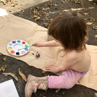 My toddler painting her rock to drop off at their rock garden!