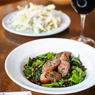 two plates of food and a glass of wine