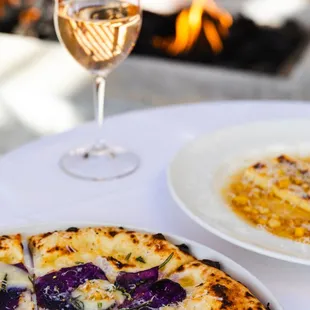 a pizza and a glass of wine