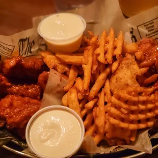 a basket of chicken wings and fries