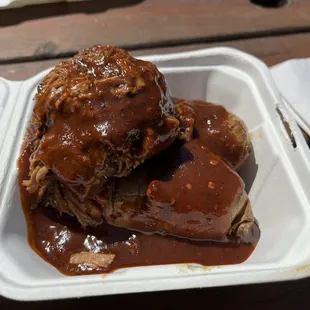 A hefty scoop of beef brisket atop two small perfectly cooked sweet potatoes