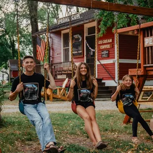 three people on a swing set