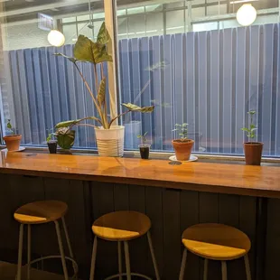 Seating toward the back of the cafe, stools looking out toward the side patio