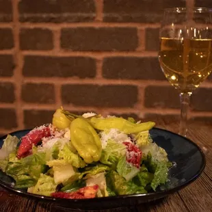 a plate of salad and a glass of wine