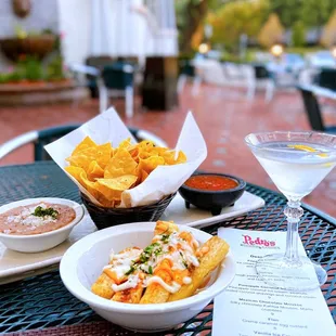 Chips, Salsa, and Bean Dip ($5), Fried Yucca ($8), Goose Martini w/ lemon twist ($13.50). Dog-friendly patio.