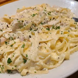 a plate of pasta with chicken and parsley