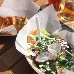 a pizza and salad on a picnic table