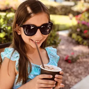a young girl drinking a drink