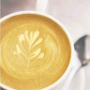 a cup of coffee with a leaf pattern
