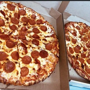 two pepperoni pizzas in a box