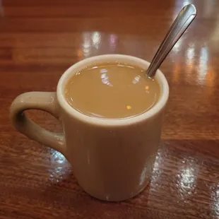a cup of coffee with a spoon in it