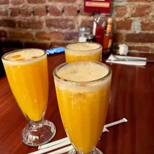 two glasses of orange juice on a table