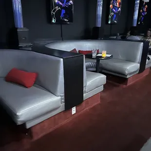 The expensive booths in the back behind the front expensive contoured chairs and tables in front of the stage.