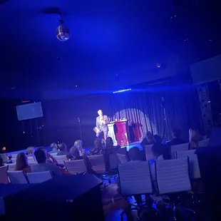 a man standing on a stage in front of a crowd
