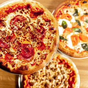 three different pizzas on a table