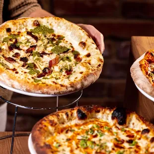 two pizzas being served on plates