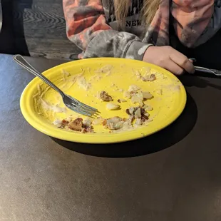This plate was stacked with a huge burrito, gravy, and potatoes. She finished this whole thing!