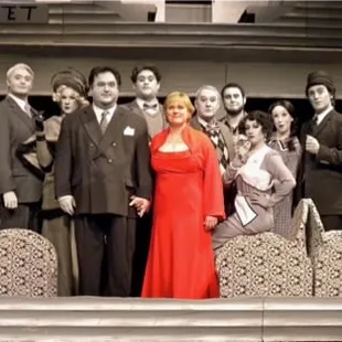 A full color photograph of the cast and the Lady in Red from Pegasus Theatre's production of Kurt Kleinmann's "Death Express!"