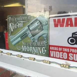 a gun and video surveillance sign