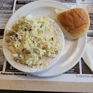 a plate of coleslaw and a roll